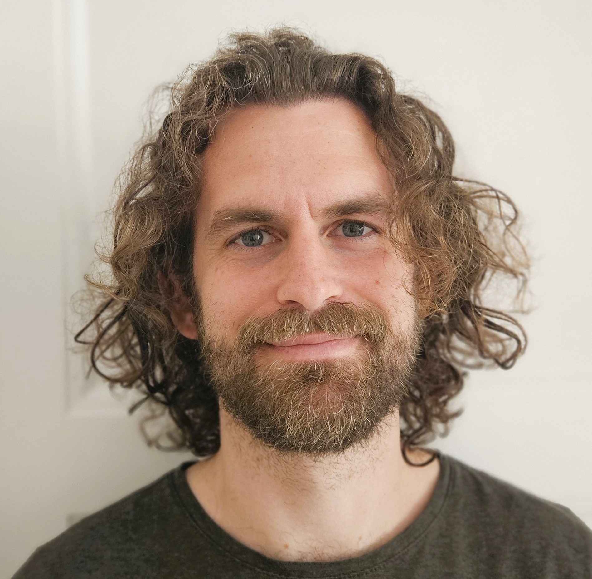 Headshot of male person, showing face, smile, clothes.